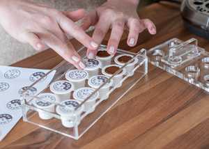 Lady filling coffee pods with ground coffee beans